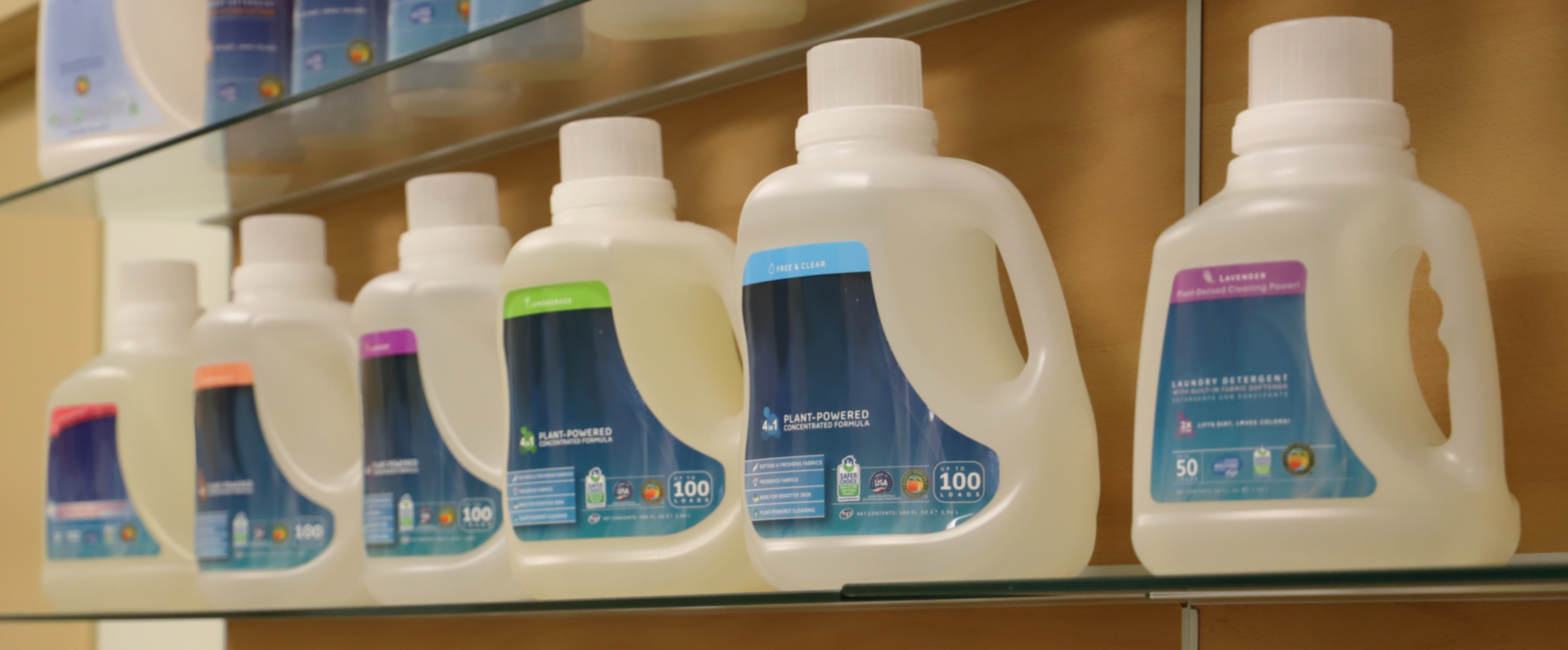 A row of generic detergent bottles on a store shelf.