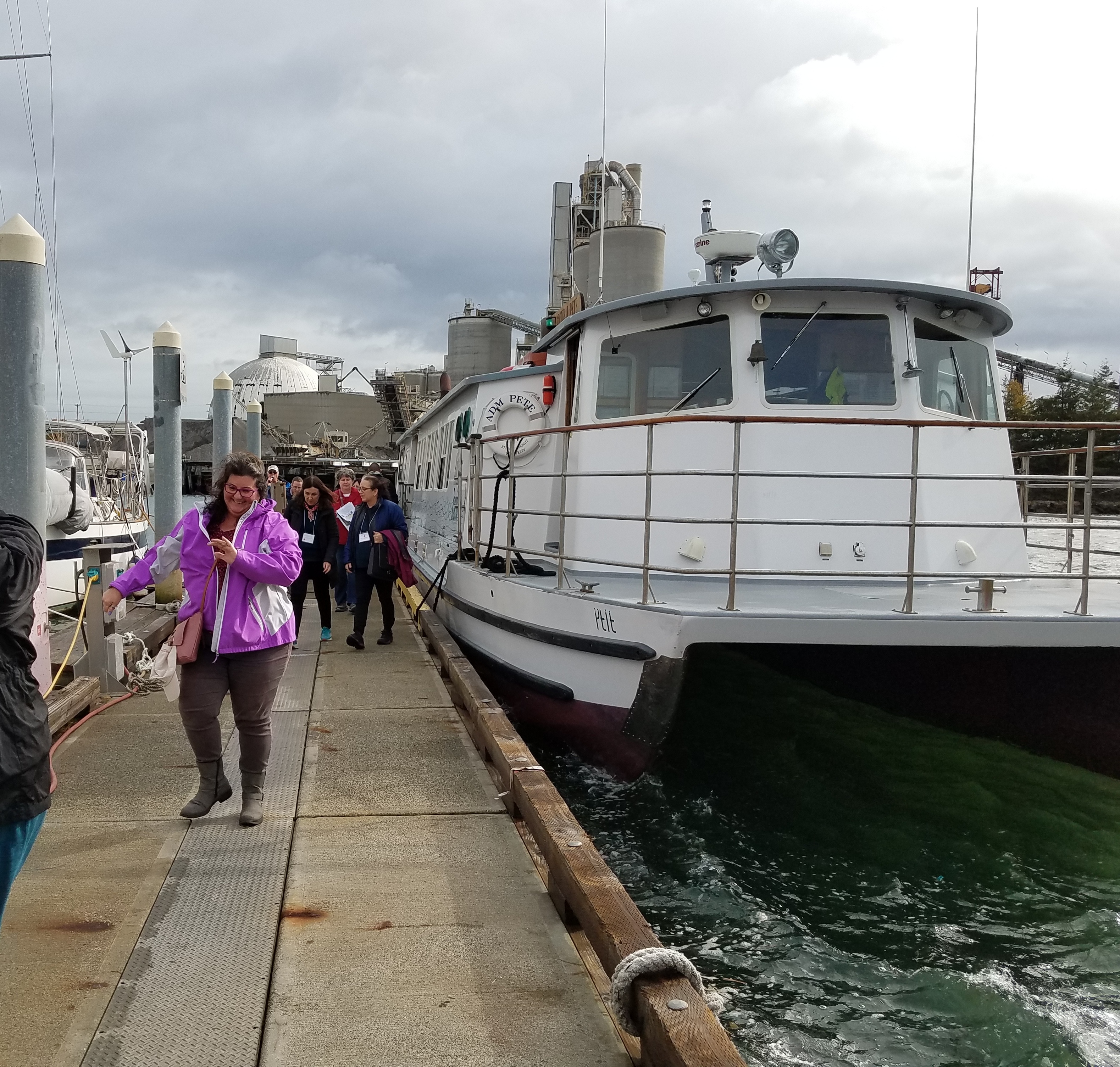 Sonia Fernández walks off a ship with Ecology employees.