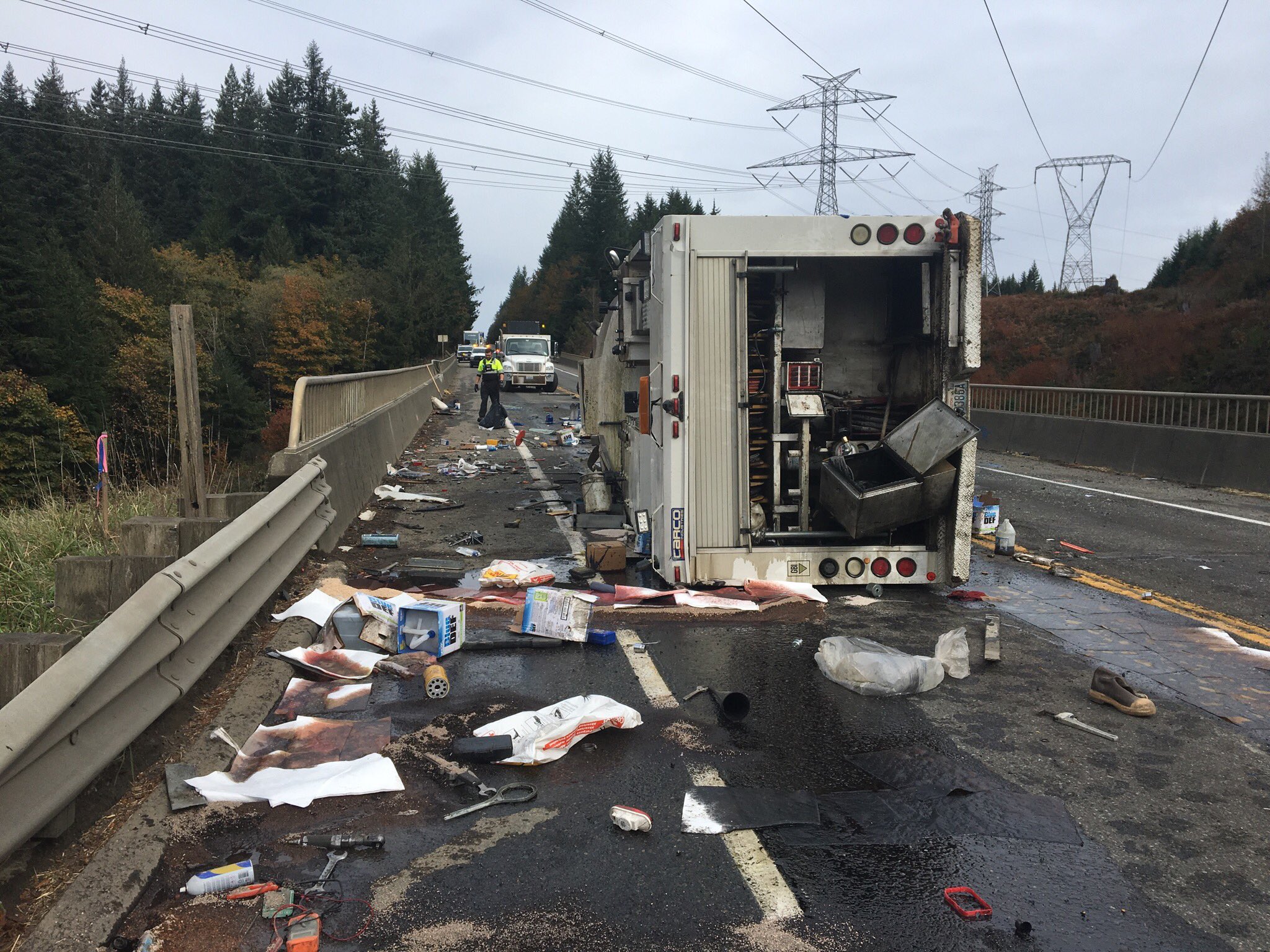 Truck on its side with fuel and other materials on the road.