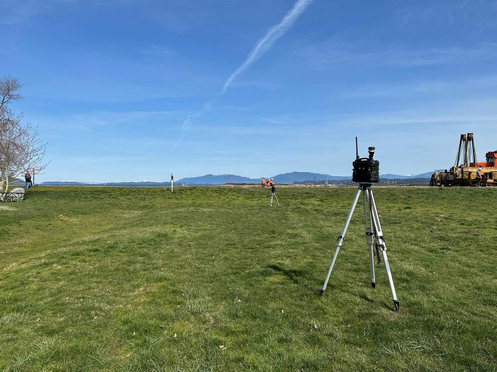 An air quality monitor on a tripod in a field.