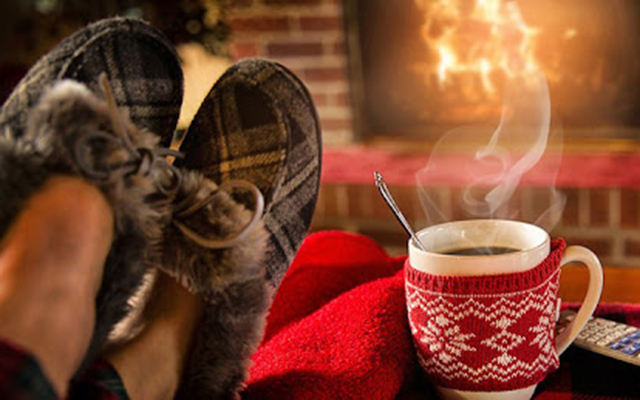 fuzzy slipper in front of a cozy fire with hot chocolate