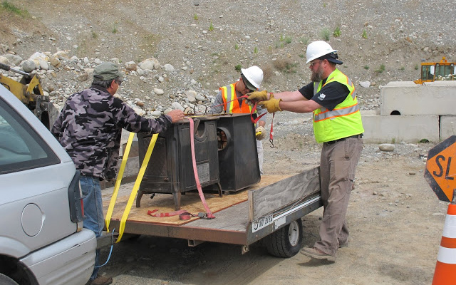 A group of men unloading old wood stoves for the wood stove roundup.