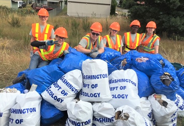 Six Ecology Youth Corp members pose with their haul of daily litter.