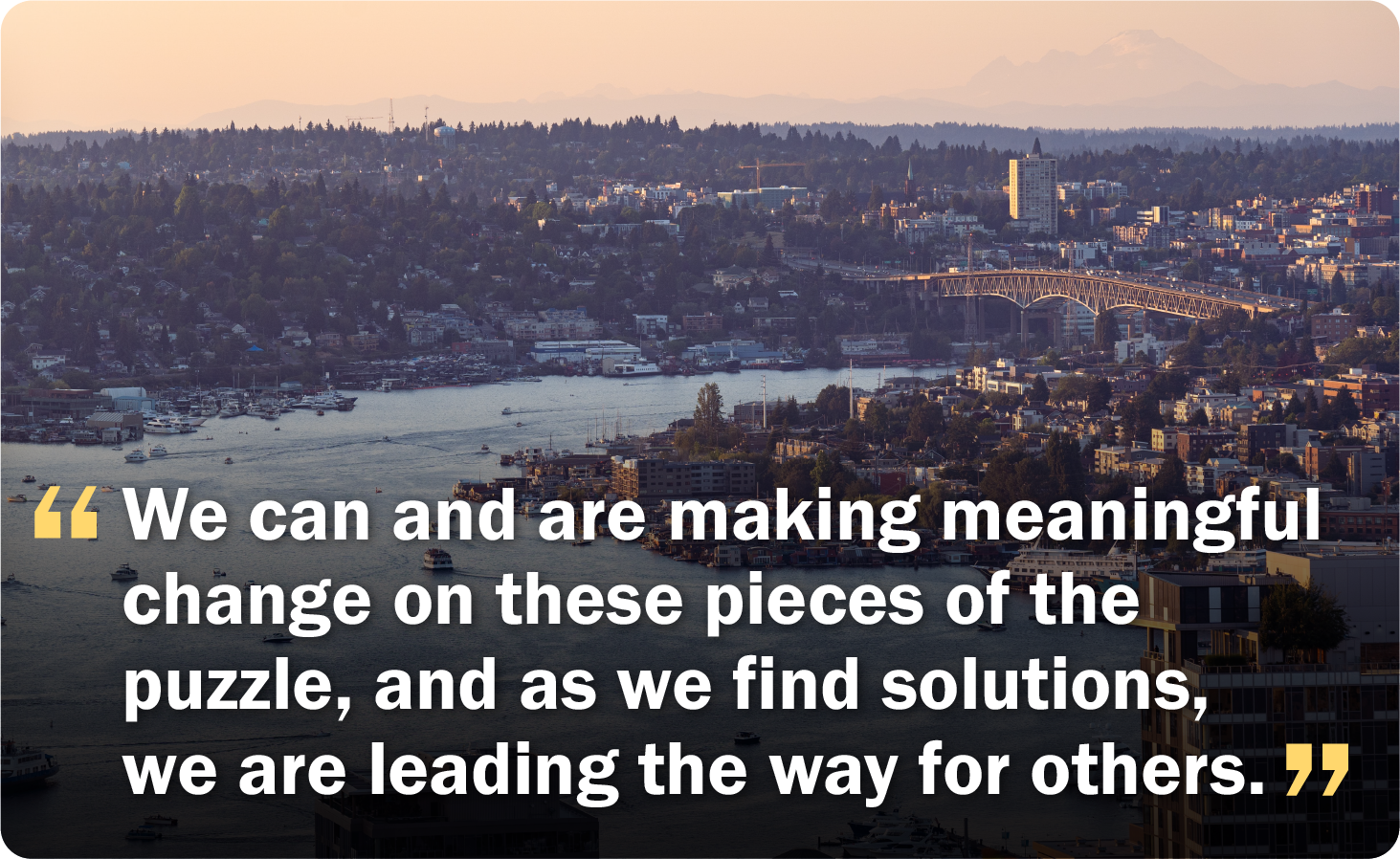 Seattle cityscape with a text overlay "We can and are making meaningful change on these pieces of the puzzle"