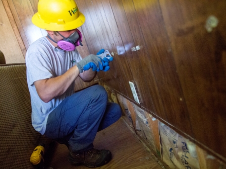 WCC AmeriCorps member checks for moisture in the walls of a home in Louisiana.