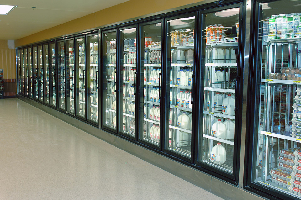 A row of commercial refrigerators in a grocery store.