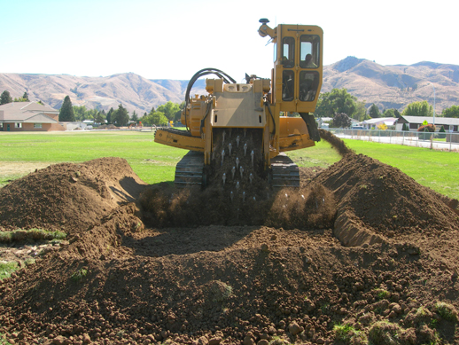 Heavy equipment removing lead- and arsenic-contaminated soil being from a playfield.