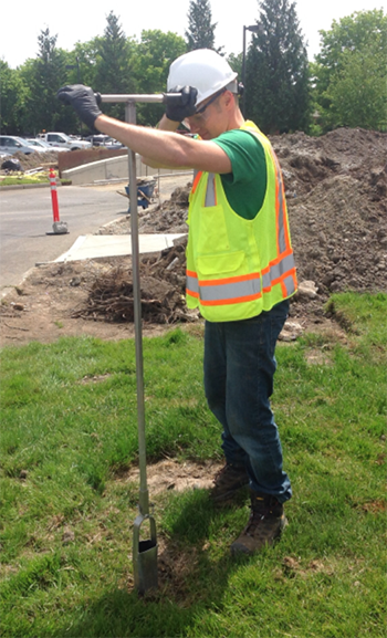Picture of a person sampling soil with a hand auger.