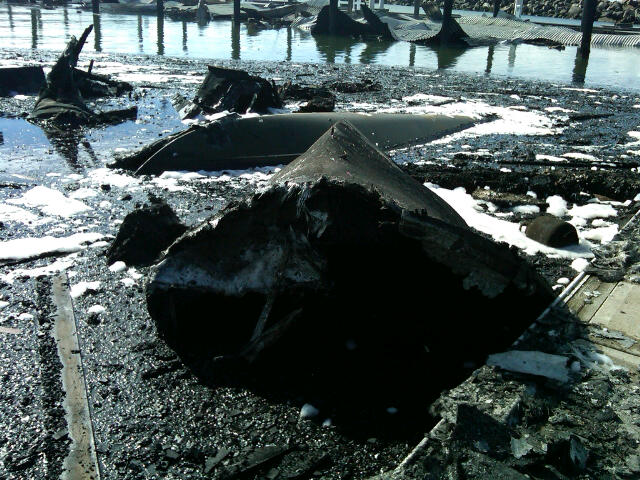 Sunken boat in marina surround by debris