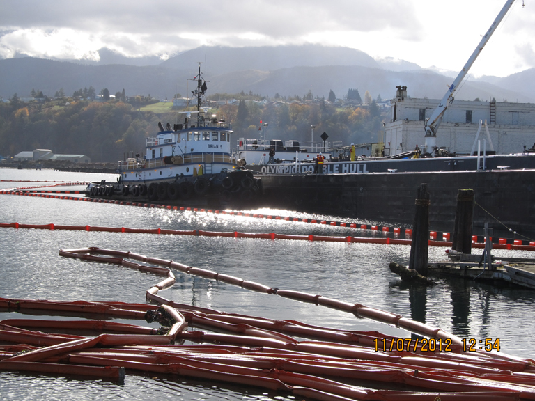 Oil spill containment boom around barge.