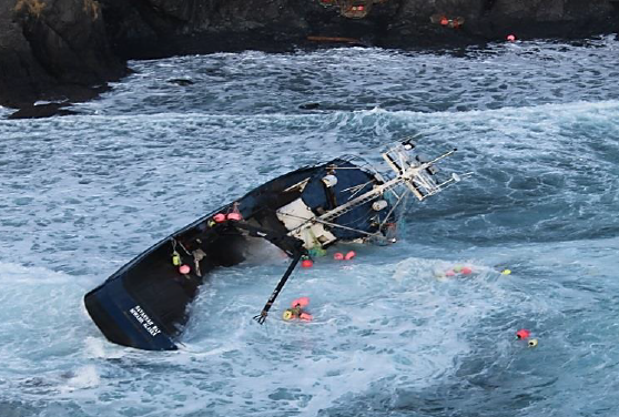 Fishing vessel SAVANNAH RAY grounded in shallow water and listing to starboard.