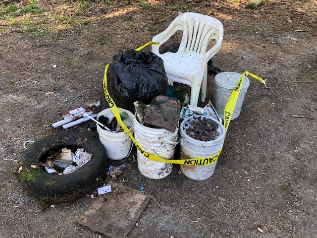 dirty buckets, an old tire, plastic chairs and other trash.