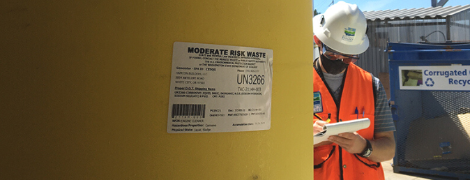 Ecology staff evaluating a tank of hazardous waste