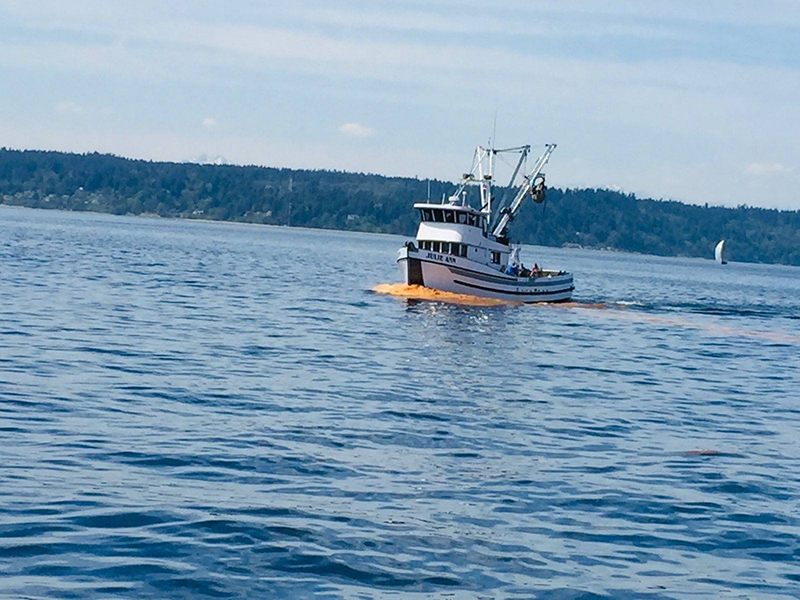 Fishing skiff — wake in front of the boat is bright orange