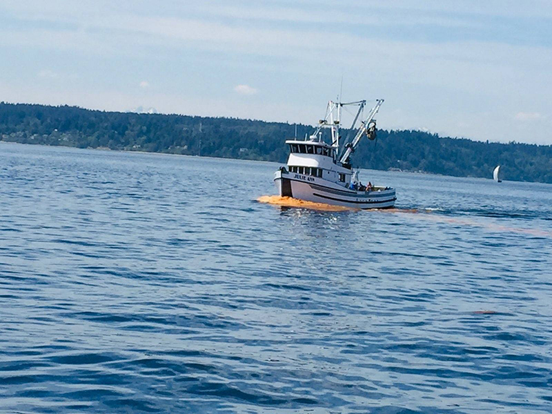 Fishing skiff — wake in front of the boat is  bright orange