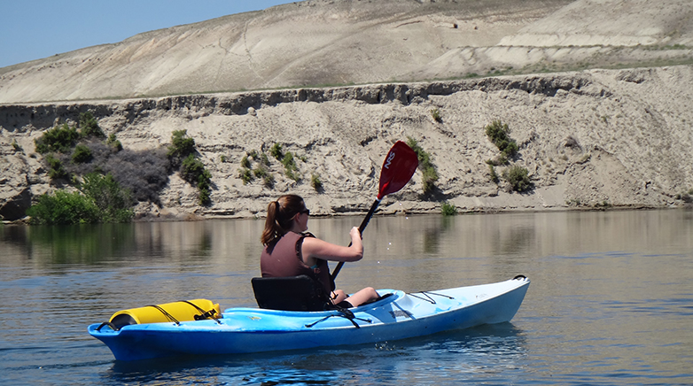 A woman in a kayak paddling on the Columbia river.