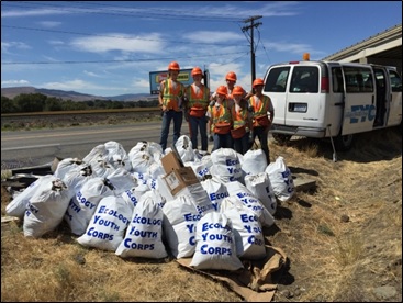 An Ecology Youth Corps crew shows off an impressive stack of litter bags picked up along the highway.