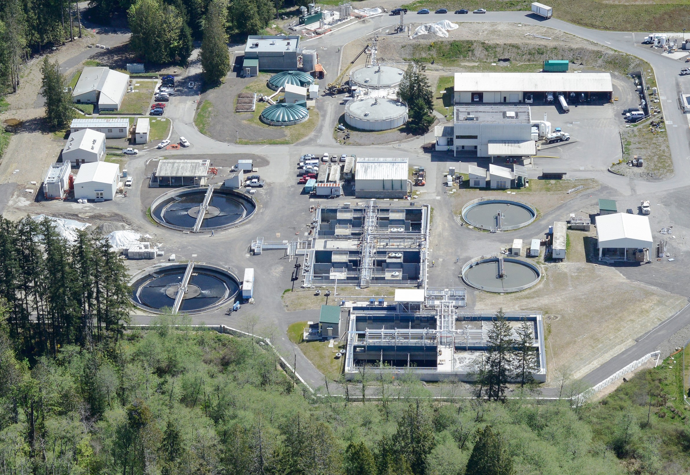 overhead view of a wastewater treatment plant surrounded by trees