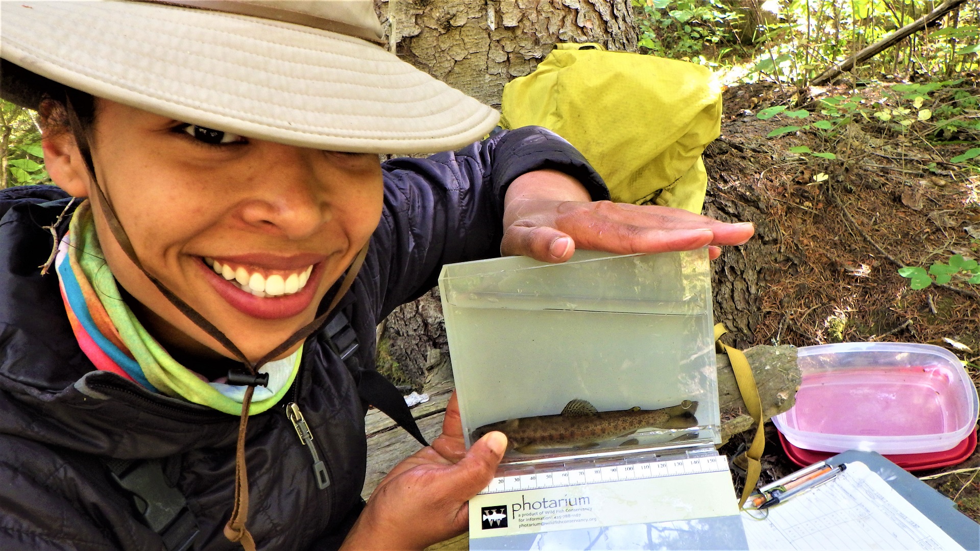 A crewmember smiling with a fish in a photarium.