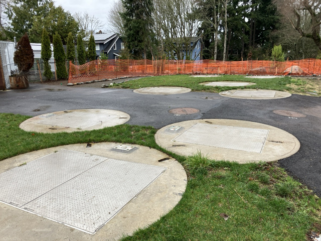 concrete circles on grassy area covering pretreatment devices