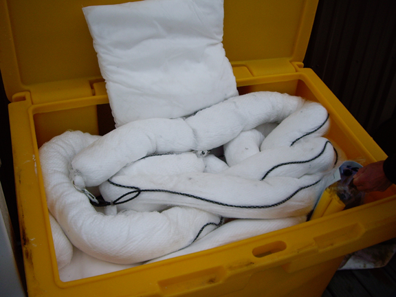 White coiled oil spill boom in a container.