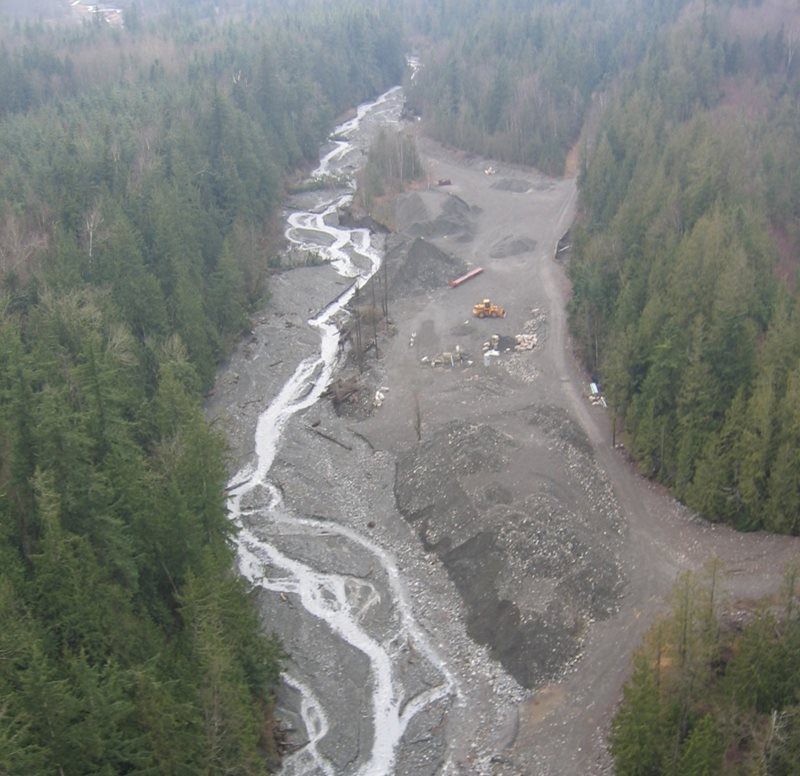 Swift Creek; fluyendo a través de áreas boscosas en ambos flancos con equipo de construcción en la planicie inundable.  