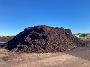 A pile of compost, appearing like brown soil.