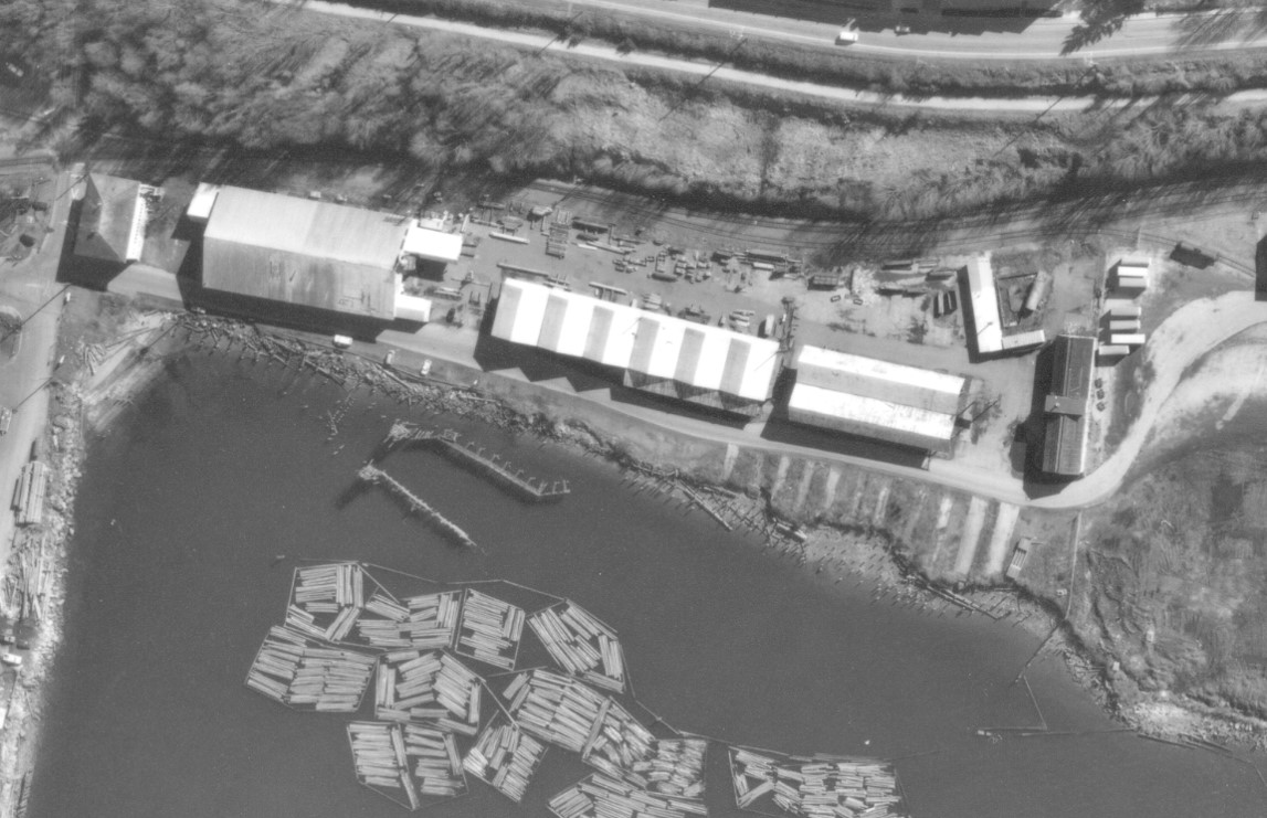 An ariel view of water and land with industrial buildings.