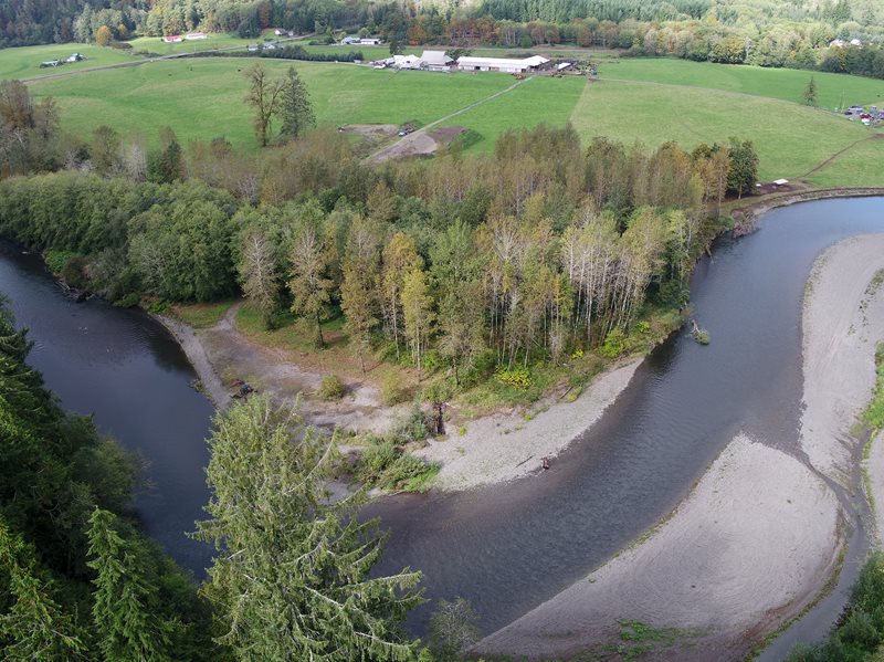 Aerial overview of Wynoochee River meandering through farmland and wooded areas.