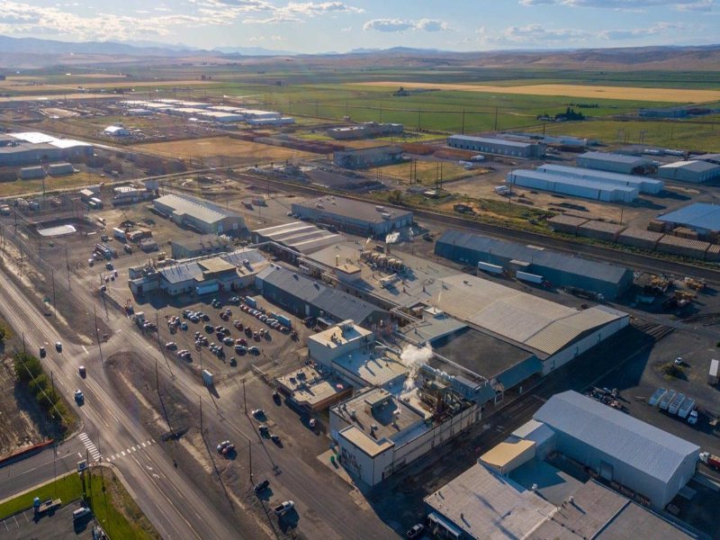 Bird's eye view of a food processing facility with farmland in the background