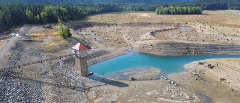A reservoir, with only a narrow strip of water below the tower