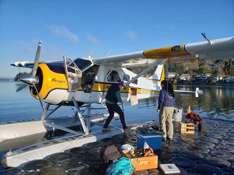 Scientist boarding yellow and white float plane