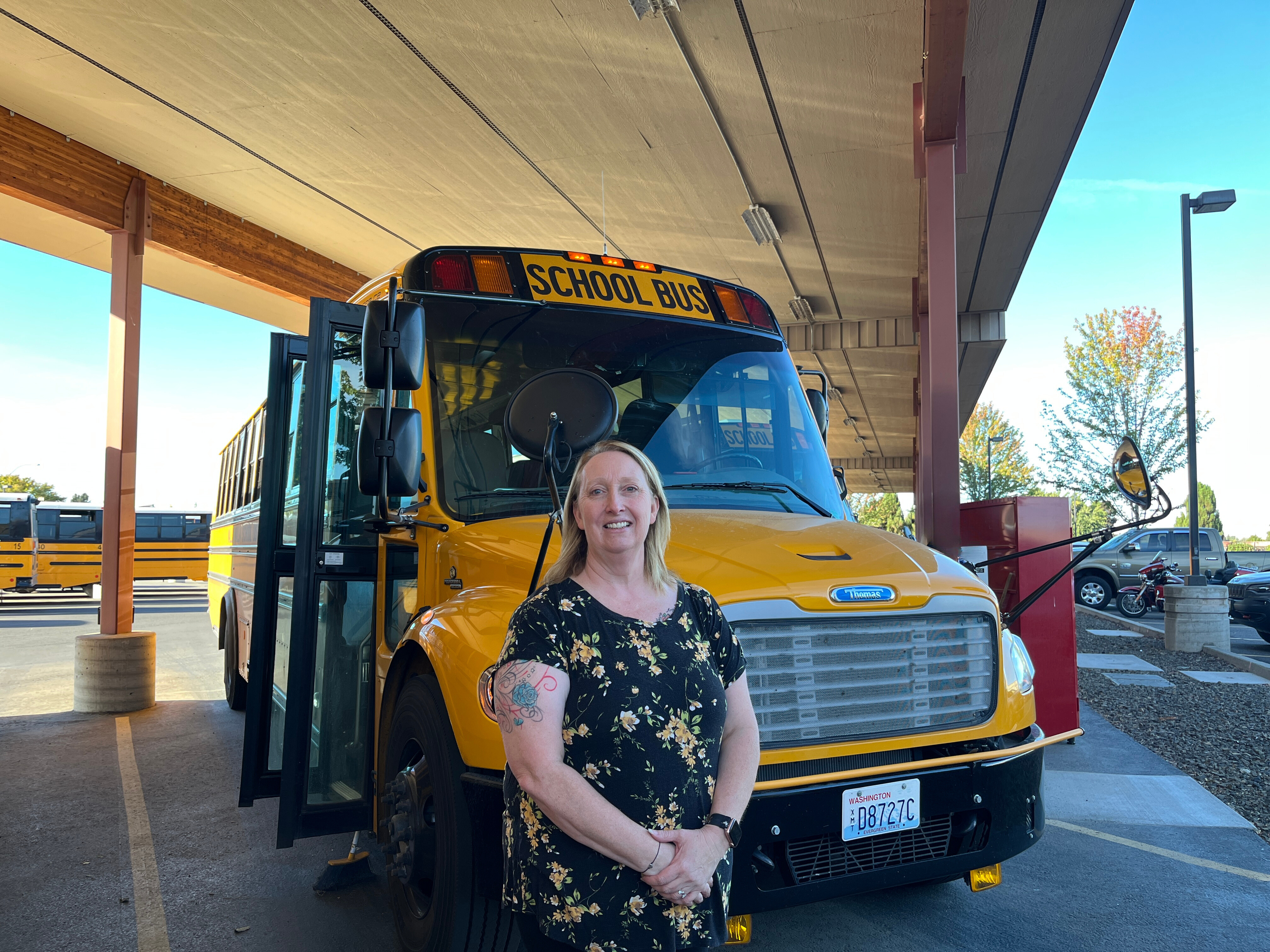 A female bus driver and an electric school bus