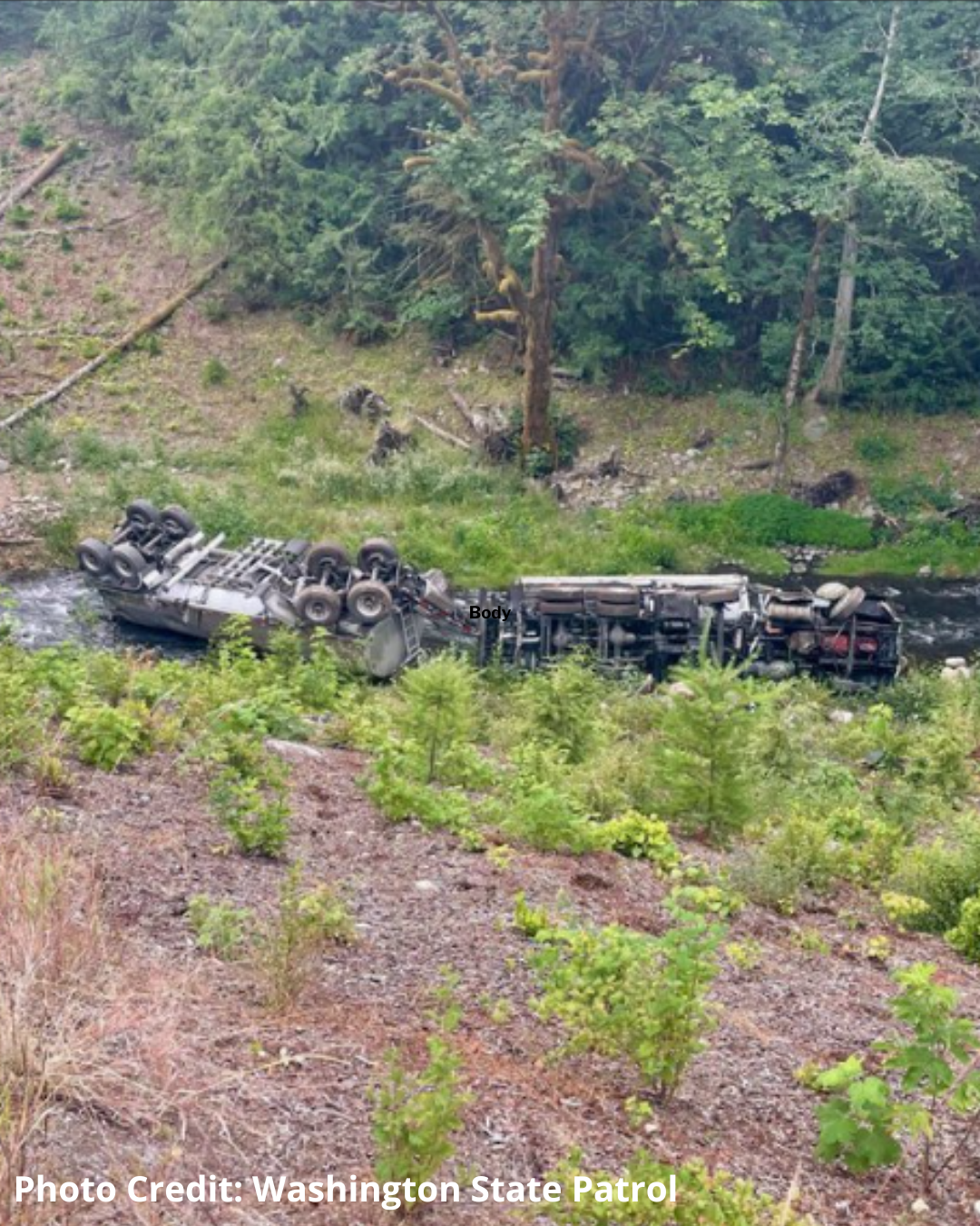 Overturned tanker truck lying on its side in Indian Creek.