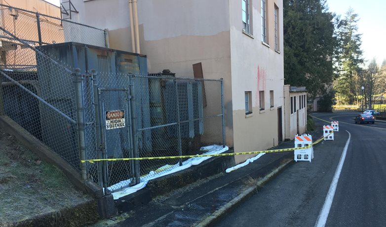 Metal box shaped transformer behind a cyclone fence at the former Olympia Brewery that spilled oil into the Deschutes River and Capitol Lake. 
