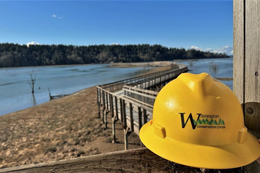 A close-up of a WCC hard hat sitting on wooden pier.