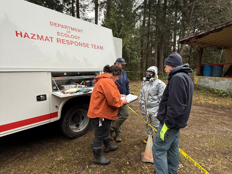 Ecology team members conducting a safety briefing beside a response truck.