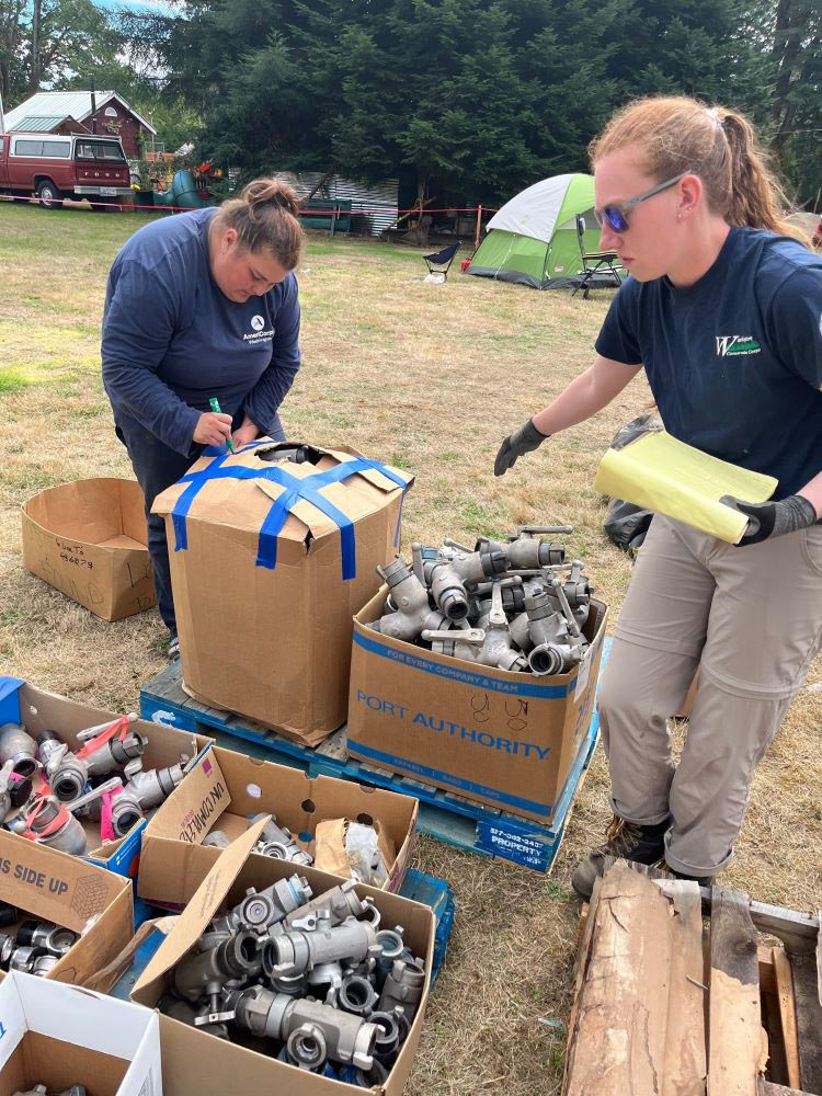 Two WCC inventory boxes of supplies in a field.