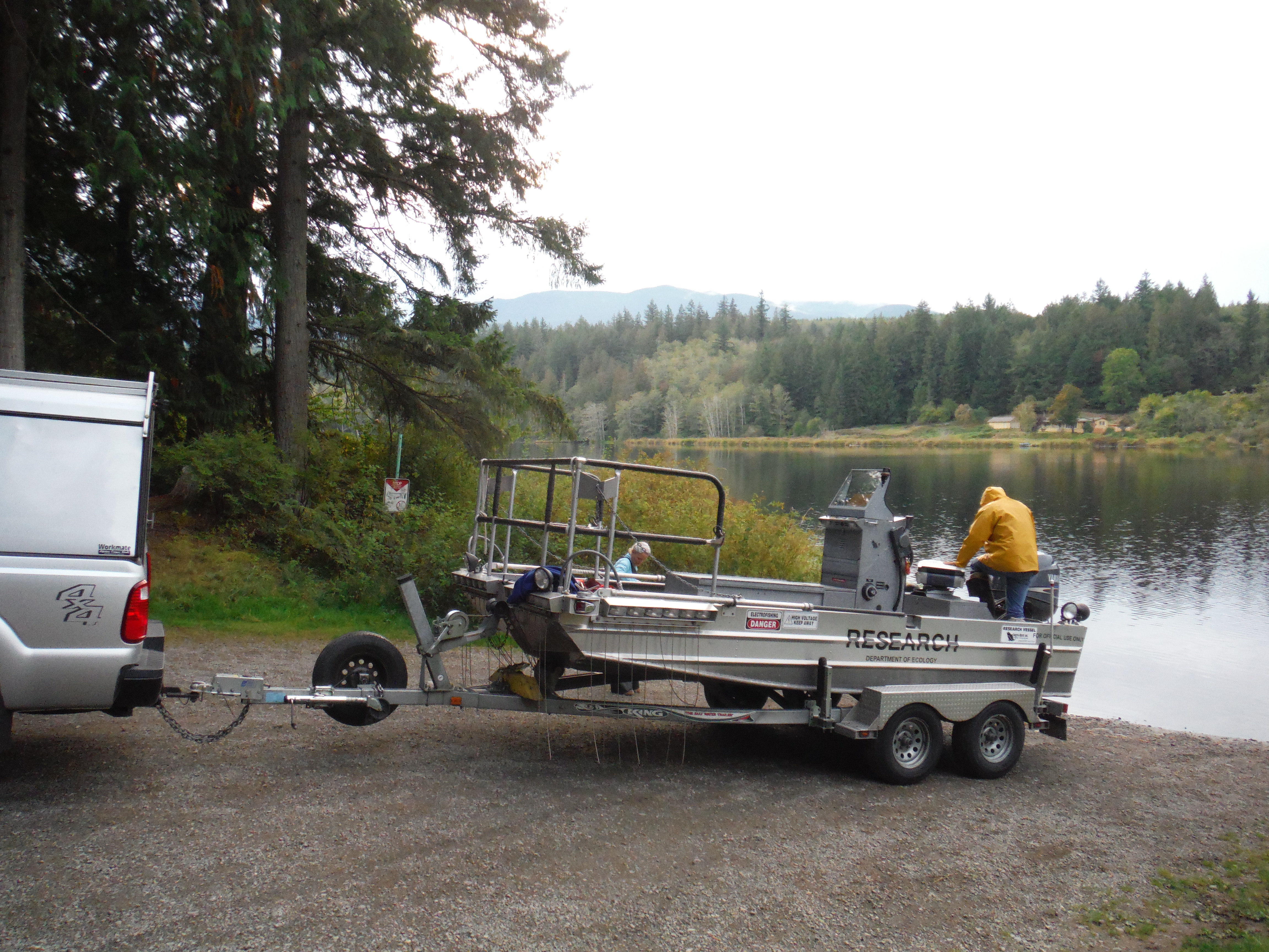 An electrofishing boat sitting on a trailer at a boat launch.