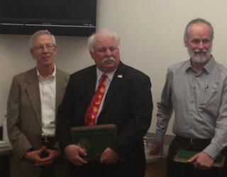 Three people, Paul Anderson, Mark Ericks, and Randy Whalen.  Mark and Randy are holding environmental excellence plaques.