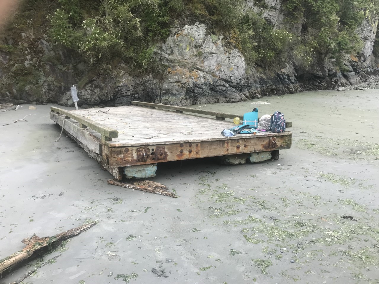 A small wooden dock on a beach with block floats made of expanded polystyrene, a material now banned in Washington for dock construction.