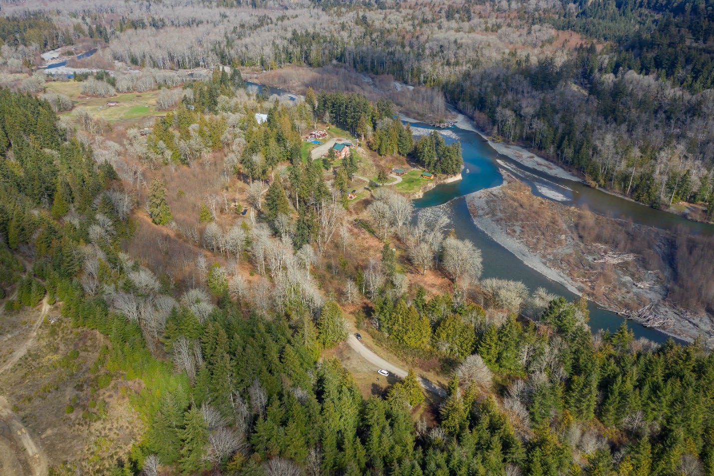 Aerial view of a braided river channel and the surrounding forested landscape.